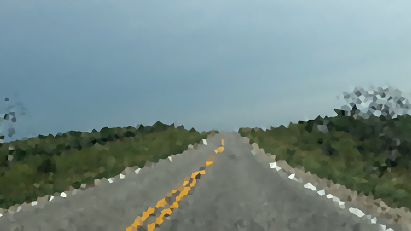 A pixelated view of an empty two-lane road.